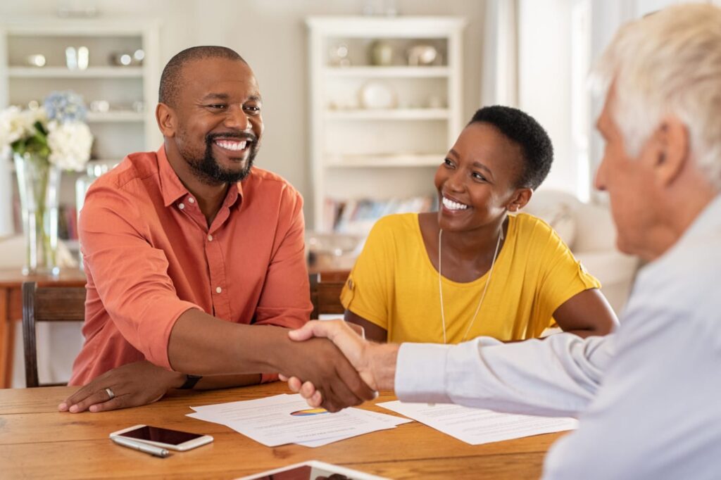 Veteran shaking hands with mortgage banker after signing a VA mortgage loan