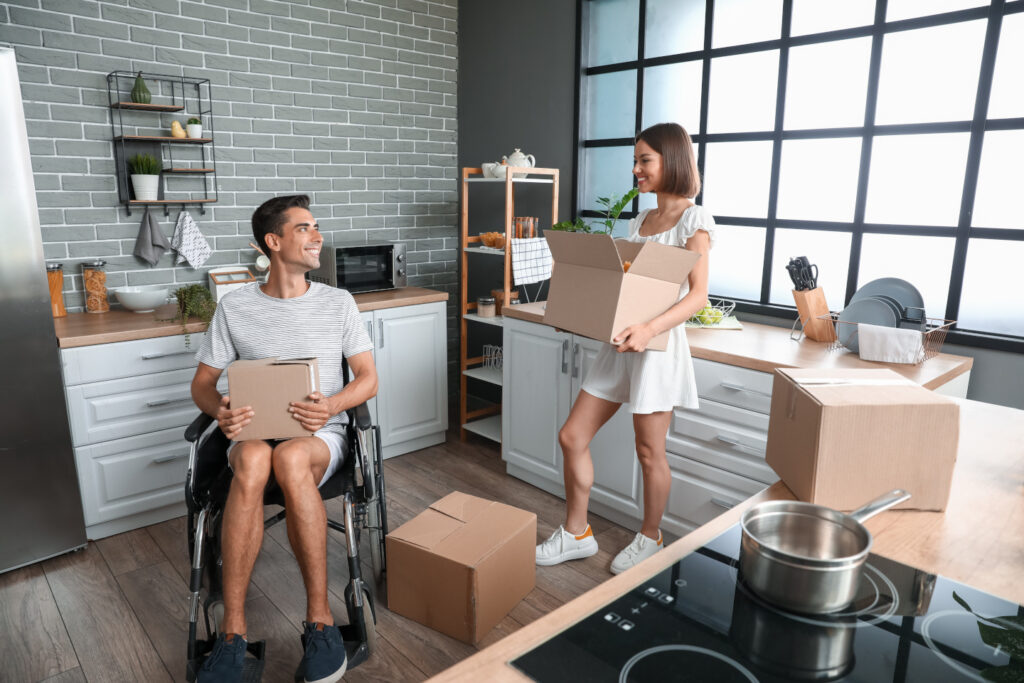 Young couple packing boxes in apartment ready to move in to new home