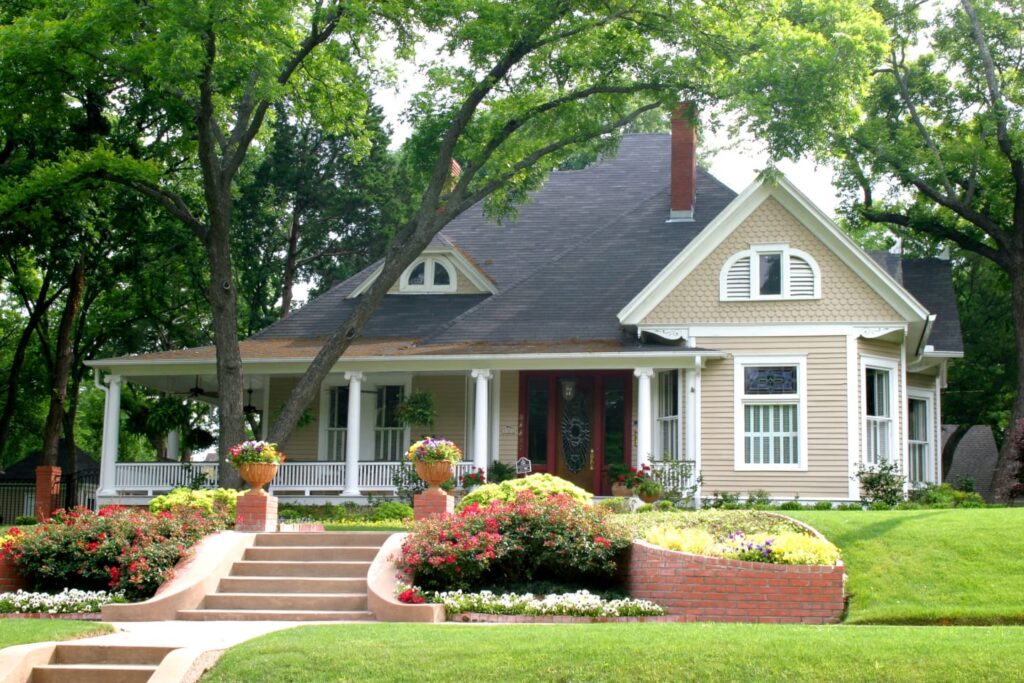 Tan modern two story house with landscaped front yard