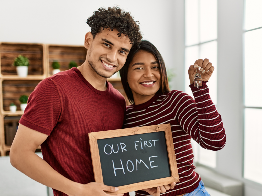 young latin couple moving into home purchased with first time home buyer assistance program