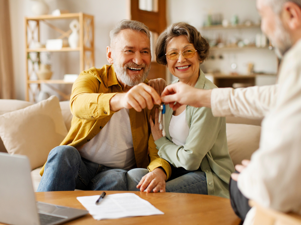 a senior couple accepts the keys to the new home they have purchased after using tips from their realtor to make financing easier for your buyers