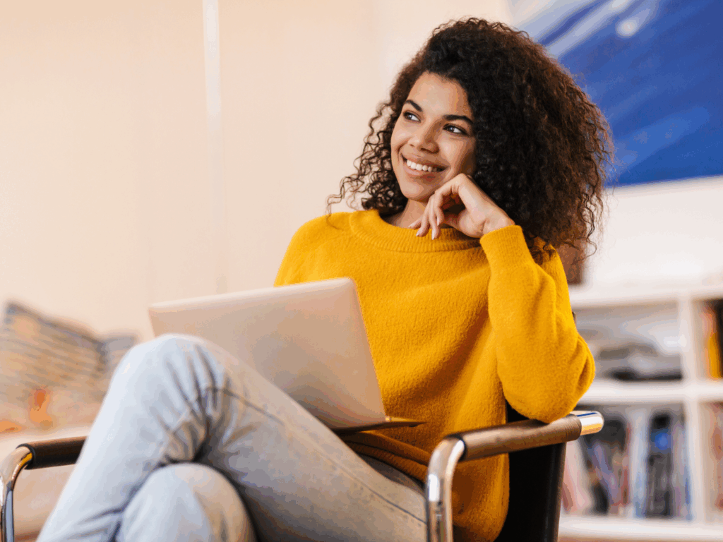 a woman looking at her laptop in her home while she considers refinancing in 2026