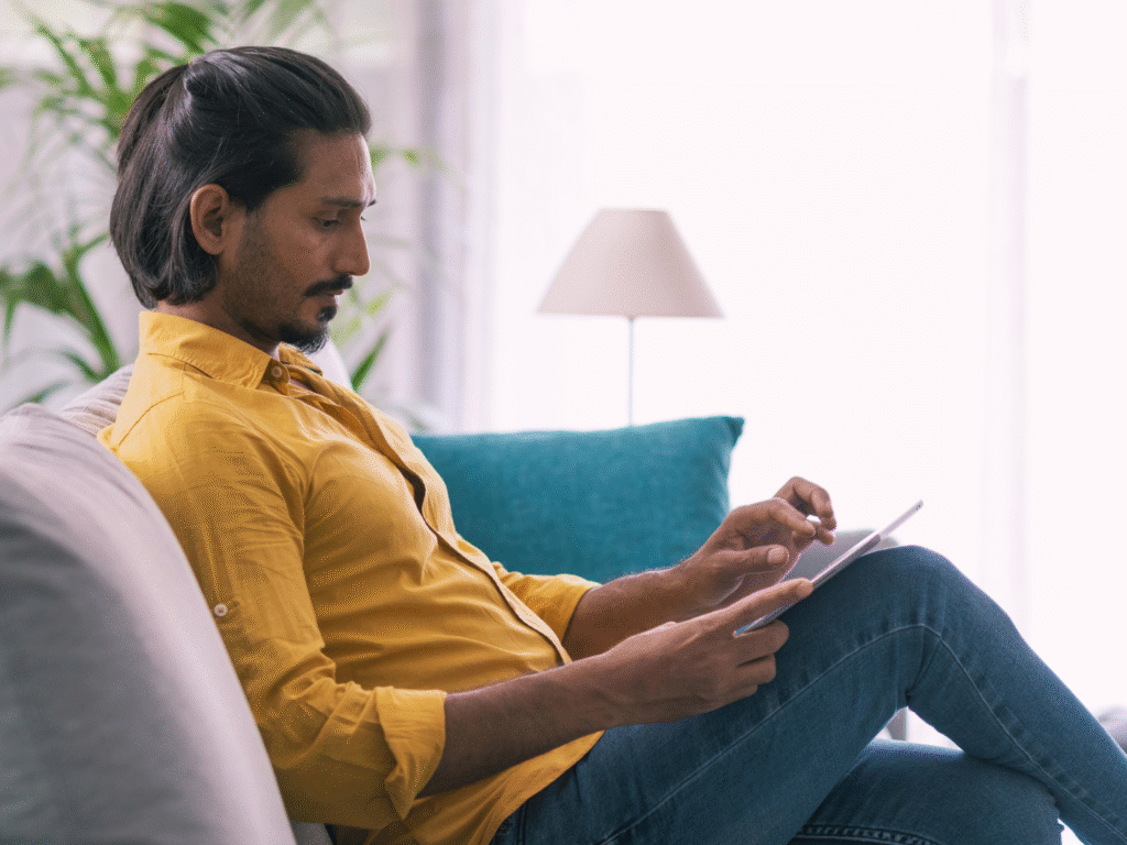 a homeowner reviewing refinancing options on his tablet in his living room