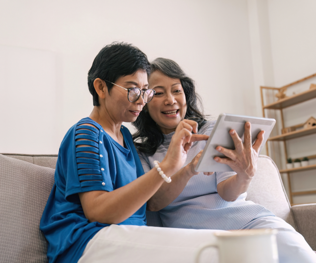 a couple in their living room deciding about mortgage refinancing when it makes sense on a tablet