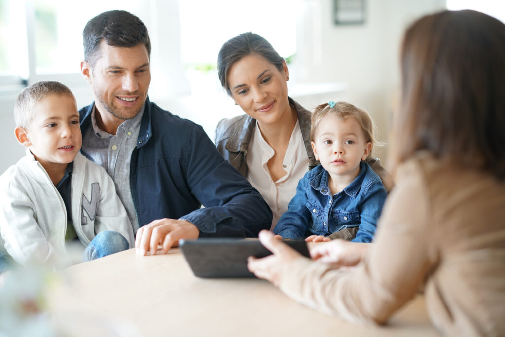 Mortgage professional meeting with homeowners to discuss refinance goals,