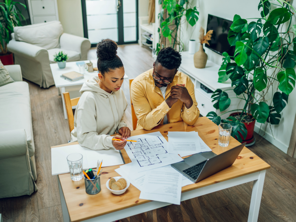 a couple in their home reviewing plans for their house before financing home renovations